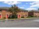 A row of brick townhomes with red doors, showcasing their uniform and appealing facade at 2886 Webb Bridge Rd, Alpharetta, GA 30009