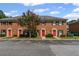 Charming townhome complex with red brick facade, red front doors, and landscaped grounds, creating curb appeal at 2886 Webb Bridge Rd, Alpharetta, GA 30009