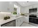 Modern kitchen with white cabinets, stainless steel appliances, and elegant countertops at 2886 Webb Bridge Rd, Alpharetta, GA 30009