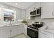 Bright kitchen showcasing stainless steel appliances, white cabinets, quartz counters, and natural light at 2886 Webb Bridge Rd, Alpharetta, GA 30009