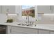 Close-up of a kitchen with a stainless steel sink, white cabinets, and lots of counter space at 2886 Webb Bridge Rd, Alpharetta, GA 30009