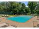 A community pool surrounded by lounge chairs and lush greenery at 2886 Webb Bridge Rd, Alpharetta, GA 30009
