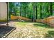 Fenced backyard with green grass and mature trees at 1131 Hershey Dr, Marietta, GA 30062