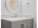 Close up of a gray vanity in a bathroom featuring a white marble countertop and round mirror at 1131 Hershey Dr, Marietta, GA 30062