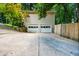 Spacious two-car garage with a long driveway and partial view of backyard fence at 1131 Hershey Dr, Marietta, GA 30062