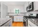 Modern kitchen featuring granite countertops, stainless steel appliances, and white subway tile backsplash at 1131 Hershey Dr, Marietta, GA 30062