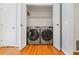 A closet containing a modern side-by-side washer and dryer set with shelving above at 1131 Hershey Dr, Marietta, GA 30062