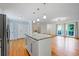 Open concept living area with hardwood floors, an island, and large windows overlooking the backyard at 1131 Hershey Dr, Marietta, GA 30062