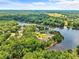 Beautiful aerial shot showcasing waterfront homes along a lake, surrounded by lush green forest under a partly cloudy sky at 55 Moray Pl, Covington, GA 30014