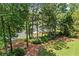 Lush backyard featuring mature trees and lake access at 55 Moray Pl, Covington, GA 30014