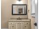 Classic bathroom with granite counters, a dark framed mirror, and white cabinets at 55 Moray Pl, Covington, GA 30014