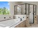 Bathroom showcasing a tub with travertine tile and a frameless glass shower enclosure at 55 Moray Pl, Covington, GA 30014