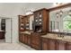 Bathroom featuring dark wood cabinetry with granite counters, dual sinks and large mirrors at 55 Moray Pl, Covington, GA 30014