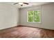 Bright bedroom featuring hardwood floors, a ceiling fan, and a large window with scenic outdoor views at 55 Moray Pl, Covington, GA 30014