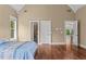 Bright bedroom with a tray ceiling, hardwood floors, and 3 doors including access to an ensuite bathroom at 55 Moray Pl, Covington, GA 30014