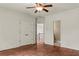 Bedroom featuring hardwood floors, ceiling fan, and doors leading to the staircase and other rooms at 55 Moray Pl, Covington, GA 30014