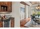 Dining room with hardwood floors adjacent to a bar and wine fridge at 55 Moray Pl, Covington, GA 30014
