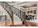 Elegant foyer featuring a curved staircase, hardwood floors, and a glimpse into the formal dining area at 55 Moray Pl, Covington, GA 30014