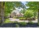Elegant brick home featuring a circular driveway, mature trees, and meticulously maintained landscaping at 55 Moray Pl, Covington, GA 30014