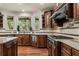 Gourmet kitchen featuring stone countertops, stainless steel appliances, and rich wood cabinetry at 55 Moray Pl, Covington, GA 30014