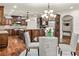 Eat-in kitchen features a glass dining table, chandelier lighting, and custom wood cabinets at 55 Moray Pl, Covington, GA 30014