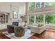 Bright living room with large windows, hardwood floors, fireplace, and comfortable seating at 55 Moray Pl, Covington, GA 30014