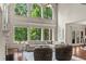 Bright living room featuring large windows with wooded views, hardwood floors, and comfortable seating at 55 Moray Pl, Covington, GA 30014