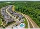 Beautiful aerial view of a neighborhood next to a lush green forest, showcasing the community pool and walking trail at 6320 Halcyon Garden Dr, Alpharetta, GA 30005