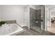 The bathroom has a separate shower and tub, and dark tile flooring at 6320 Halcyon Garden Dr, Alpharetta, GA 30005