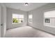 Empty bedroom with light carpet and two windows at 6320 Halcyon Garden Dr, Alpharetta, GA 30005