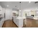Open-concept kitchen with a large island, stainless steel appliances, and hardwood floors, connecting to the living area at 6320 Halcyon Garden Dr, Alpharetta, GA 30005