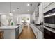 Contemporary kitchen boasts a center island, stainless appliances, and stylish lighting, flowing into dining space at 6320 Halcyon Garden Dr, Alpharetta, GA 30005