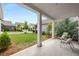 Back patio with seating overlooking a well-maintained lawn and manicured shrubbery at 6320 Halcyon Garden Dr, Alpharetta, GA 30005