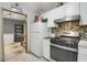 Galley kitchen featuring a gas range, classic white appliances, and tiled floor, with room for expansion at 652 Post Oak Rd, Jonesboro, GA 30238