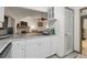 Bright kitchen featuring white cabinets, stone countertops, and open layout to the living area at 652 Post Oak Rd, Jonesboro, GA 30238