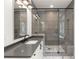 Modern bathroom boasts sleek gray tiles, frameless glass shower, and elegant vanity with dark countertops at 779-A Lynwood Se St, Atlanta, GA 30312