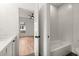 Bright bathroom featuring herringbone tile shower over tub, white vanity, and wood-look floors at 779-A Lynwood Se St, Atlanta, GA 30312