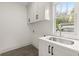 Bright laundry room features white cabinetry, a sink, modern fixtures, and natural light at 779-A Lynwood Se St, Atlanta, GA 30312