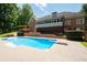 Brick home exterior with backyard in-ground pool and second-story screened in porch for entertaining at 1642 Reflections Trl, Powder Springs, GA 30127
