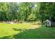 Large grassy backyard, surrounded by mature trees, features an in-ground pool and fence at 1642 Reflections Trl, Powder Springs, GA 30127