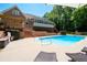 Brick home exterior featuring an in-ground pool and connected deck, perfect for outdoor living and entertaining at 1642 Reflections Trl, Powder Springs, GA 30127