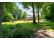 Picturesque backyard with a small creek, bridge, mature trees, and a fenced-in yard at 1642 Reflections Trl, Powder Springs, GA 30127