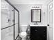 Bathroom featuring a vanity with a black cabinet, a toilet, and glass enclosed shower, decorated with a mirror and modern fixtures at 1642 Reflections Trl, Powder Springs, GA 30127