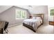 Bedroom showcasing a full bed, carpeted floors, natural lighting from a window, and a dark wooden desk at 1642 Reflections Trl, Powder Springs, GA 30127