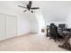 Spacious room featuring neutral carpet, a ceiling fan, a large closet, and a desk with office chair, perfect for a bedroom or office at 1642 Reflections Trl, Powder Springs, GA 30127