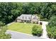 Aerial view of brick home with well-maintained lawn and mature trees, showcasing its curb appeal at 1642 Reflections Trl, Powder Springs, GA 30127