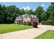 Beautiful brick home with a well-manicured lawn, mature trees, and a long driveway at 1642 Reflections Trl, Powder Springs, GA 30127