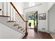 The well lit foyer features hardwood floors and a staircase with an open door to the front yard at 1642 Reflections Trl, Powder Springs, GA 30127