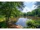 Scenic view of a serene pond surrounded by lush trees and greenery at 1642 Reflections Trl, Powder Springs, GA 30127