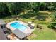 Aerial view of a sparkling pool, surrounding deck, lounge chairs, and lush landscaping at 1642 Reflections Trl, Powder Springs, GA 30127
